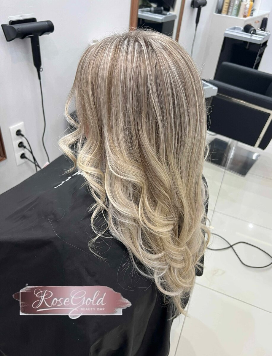 Langer blonder Stufenschnitt mit voluminösen Locken bei Rose Gold Beauty Bar OG